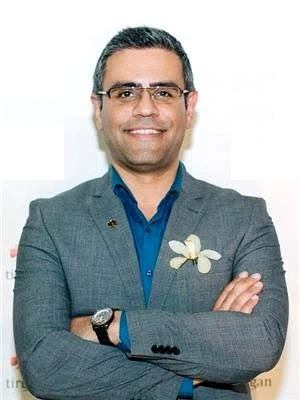Portrait of Hosein Amooshahi in a grey blazer and blue shirt